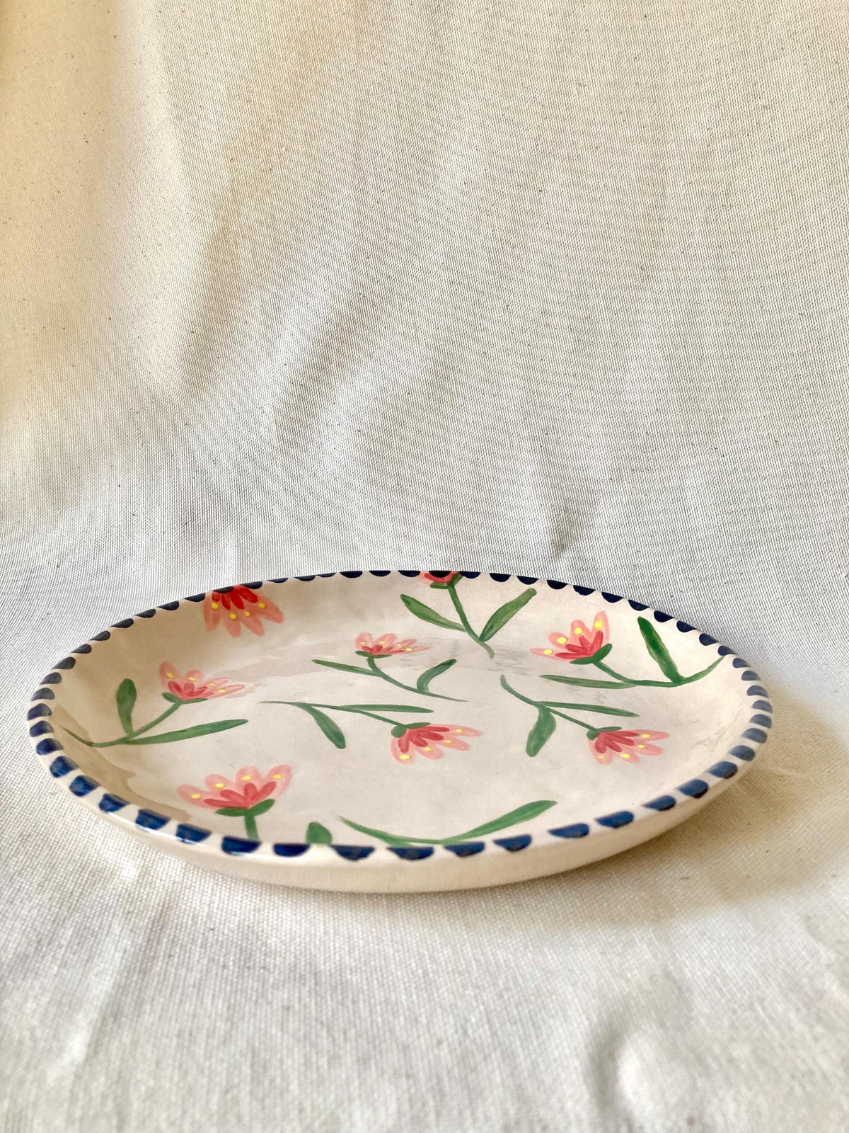Assiette céramique fleurs roses, rouges et jaune, liseré noir