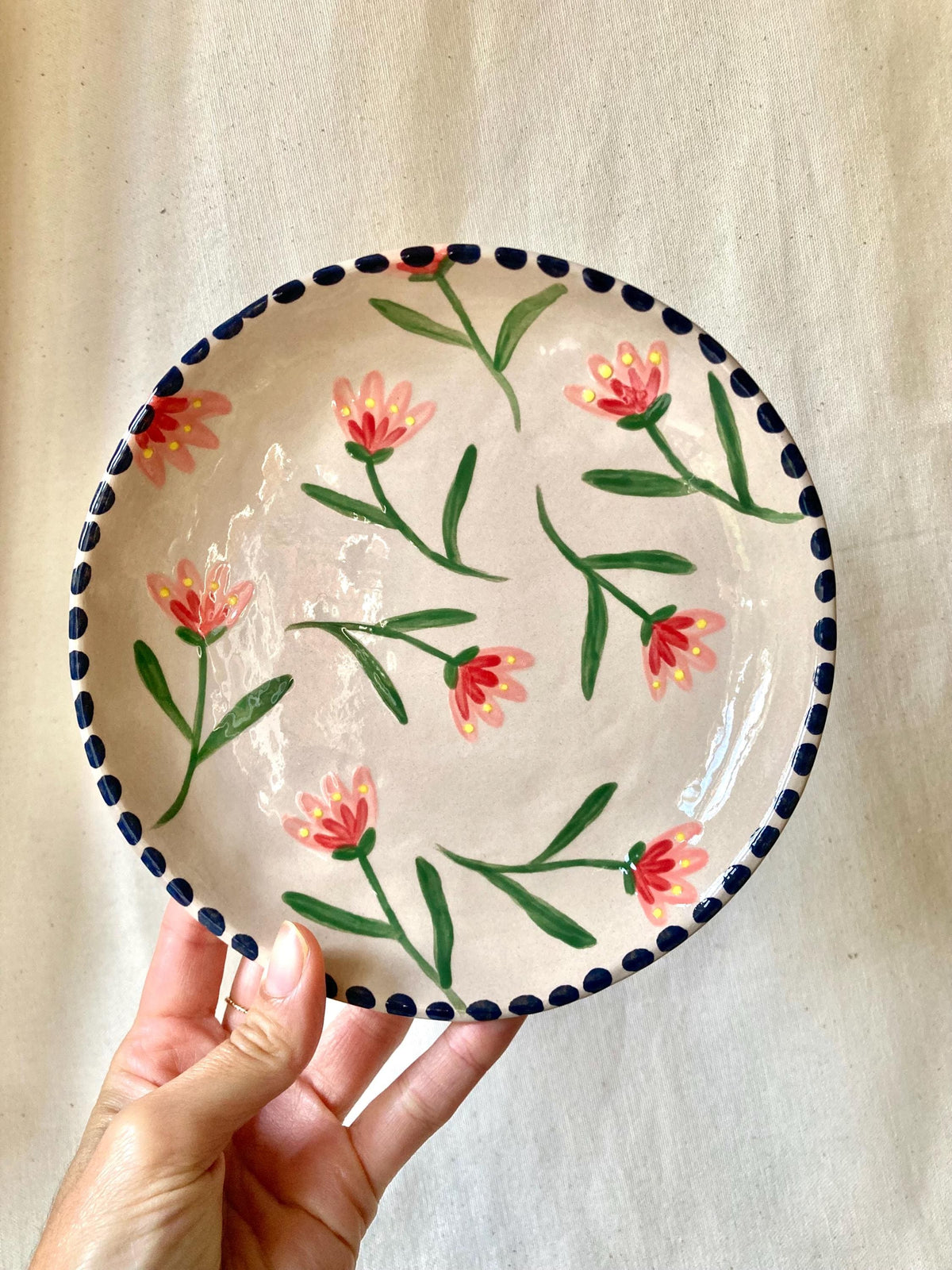 Assiette céramique fleurs roses, rouges et jaune, liseré noir