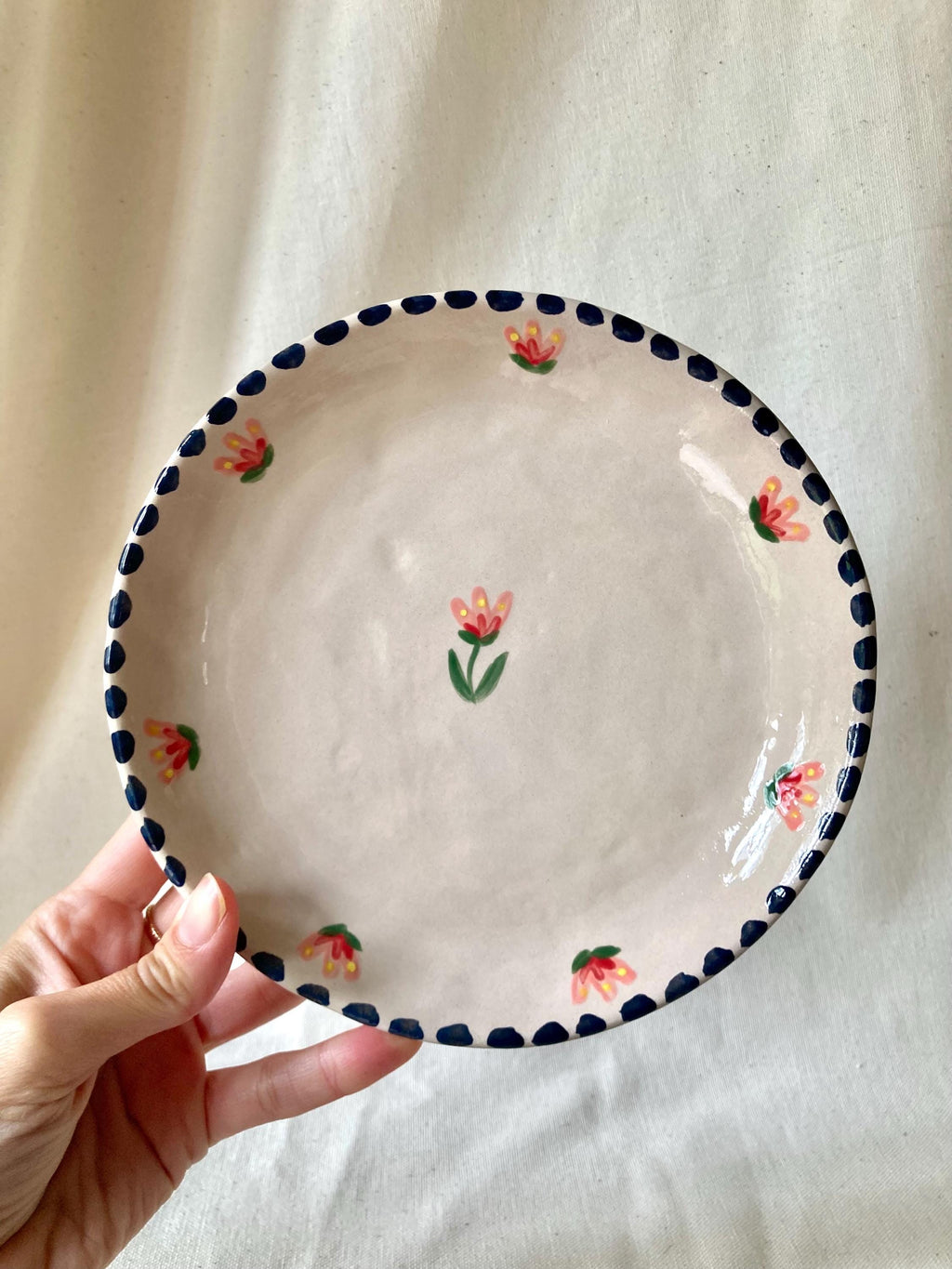 Assiette céramique couronne de fleurs roses et rouges, liseré noir