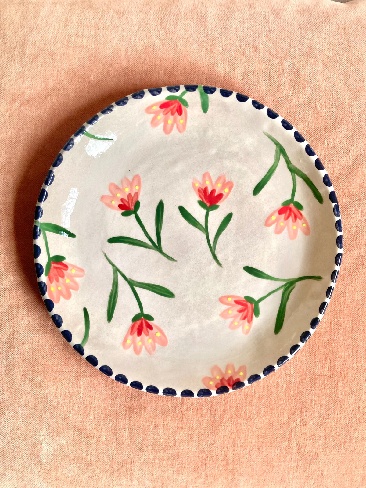 Assiette céramique fleurs roses, rouges et jaune, liseré noir