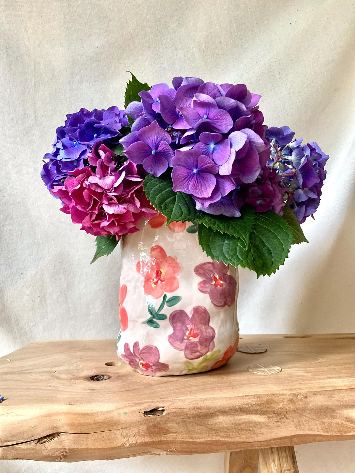 Vase céramique déformé fleurs roses et violettes